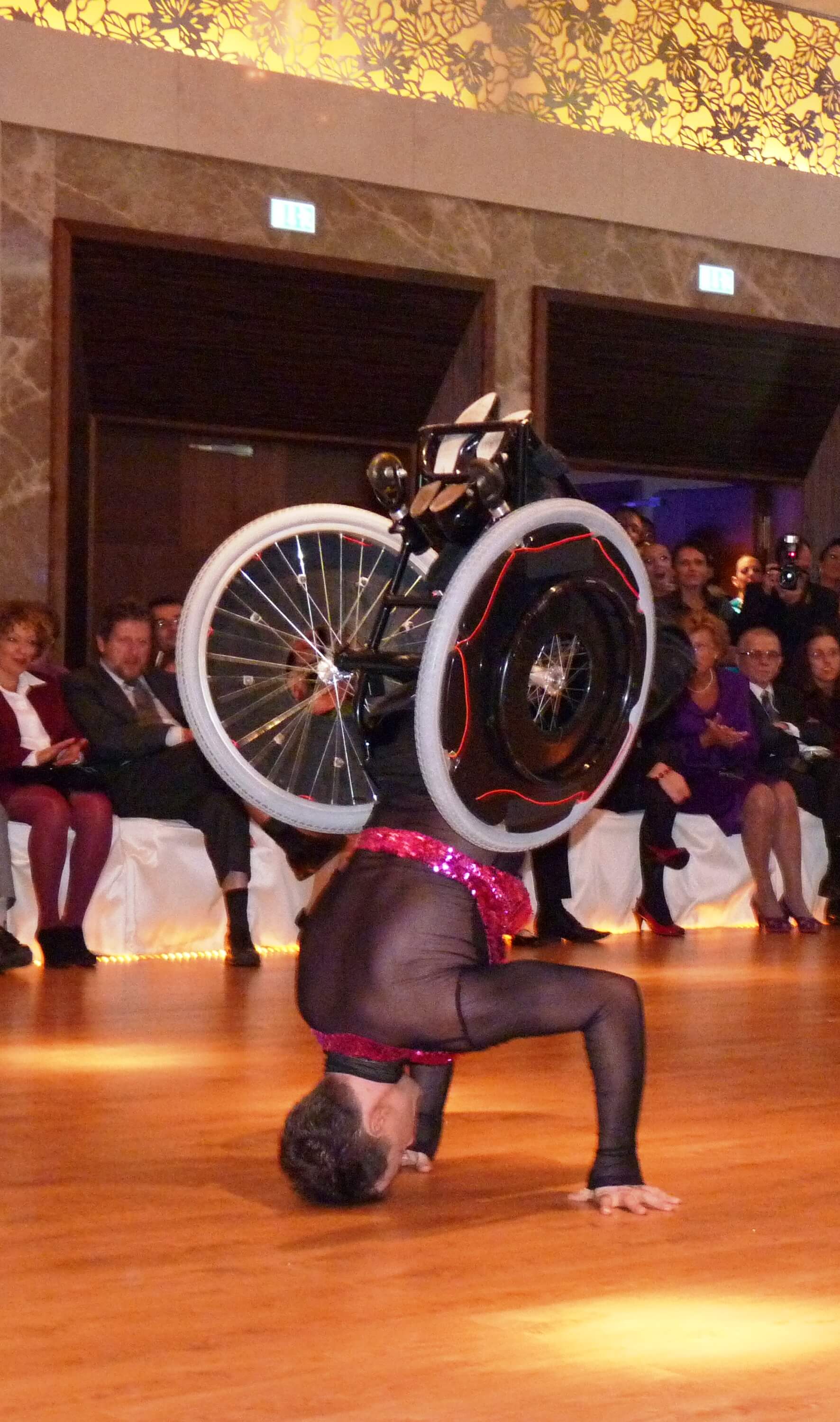 Človek na invalidnom vozíku robí stojku
